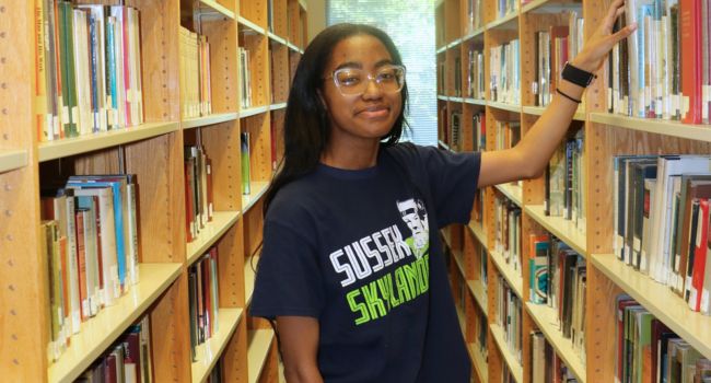 Student selecting a book to read in the SCCC library